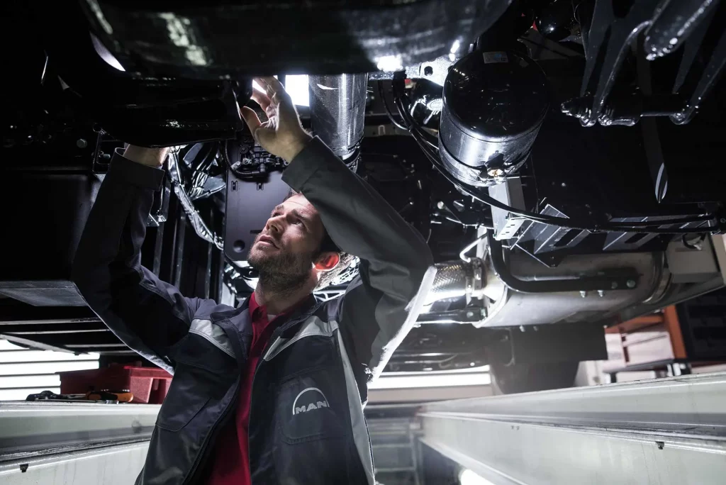 MAN-Servicetechniker unter einem LKW